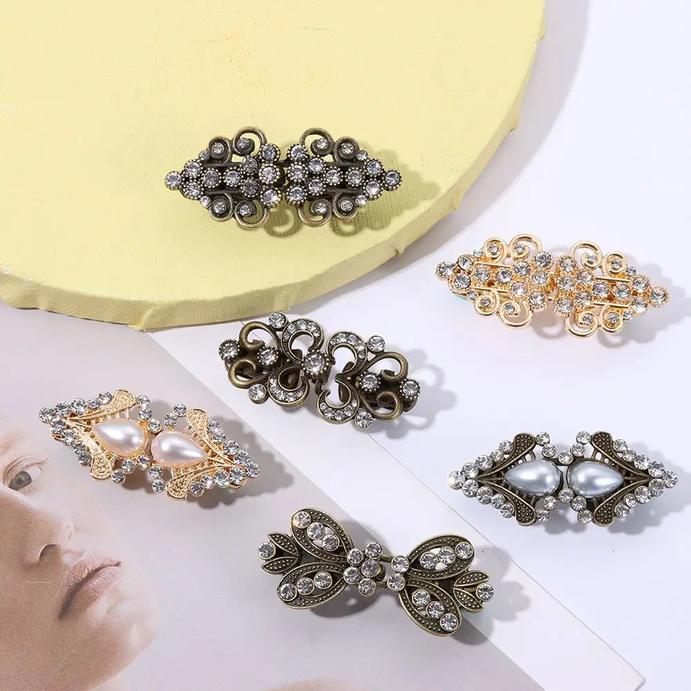 A collection of vintage swirl clip brooches in silver and gold tones displayed on a light yellow background.