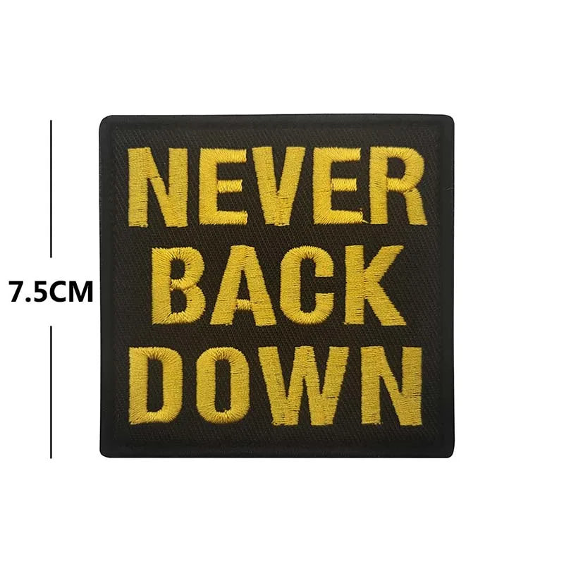 Black embroidered patch with gold text reading NEVER BACK DOWN