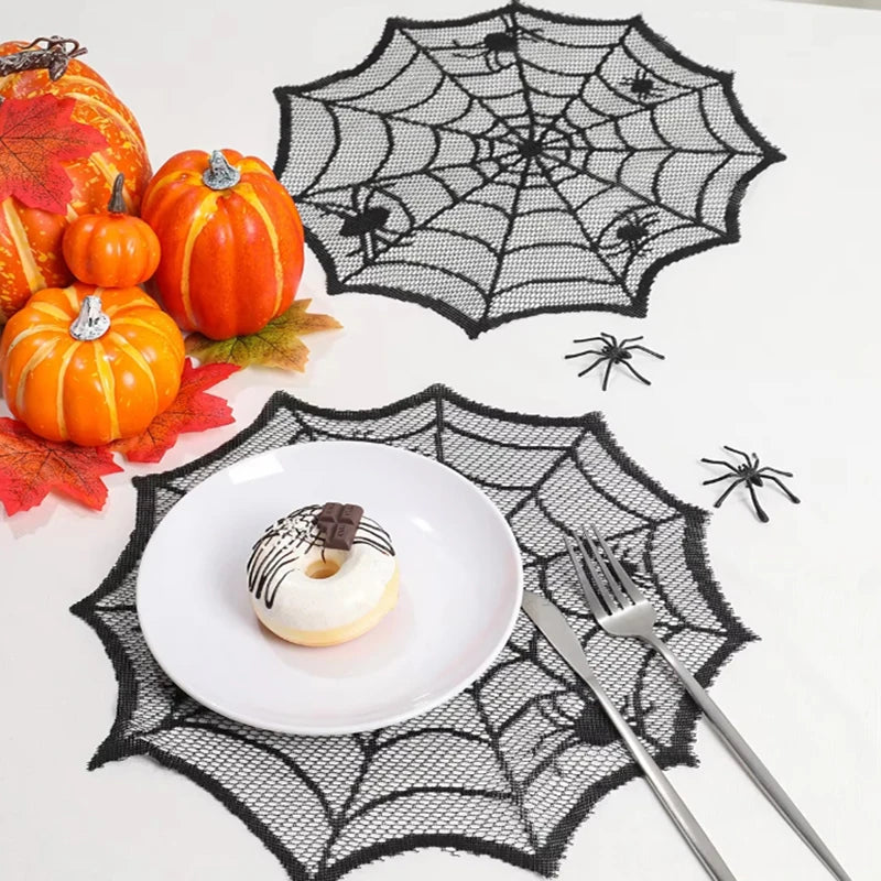 A festive autumn display featuring pumpkins, a white donut, and a black spider web design on a white surface.