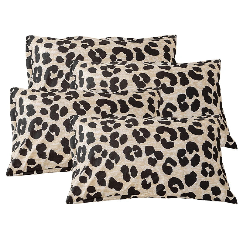 A set of two leopard print decorative pillow covers in black and beige spots.
