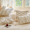 A collection of cream and beige bohemian knit pillow covers displayed on a light-colored sofa.