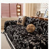 A black and white floral patterned chenille sofa slipcover displayed on a light-colored sofa with natural light.