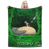 A green forest scene featuring the Totoro character on a fleece throw blanket.