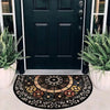 A vintage stone doormat with a colorful, circular pattern lies on a light-colored porch.