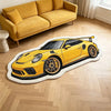 A yellow sports car shaped plush rug lying on a light wood floor next to a sofa.