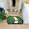 A green and yellow cartoon dollar tufted bathroom rug placed on a light wood floor.