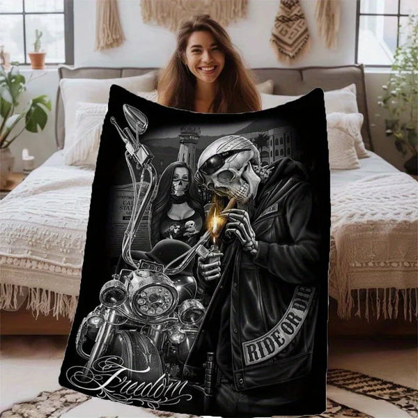 A dark flannel throw blanket featuring a graphic design of a motorcycle skull and rider.