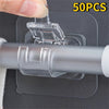 A hand is attaching a clear self-adhesive curtain rod clip to a gray window frame using a transparent adhesive pad.