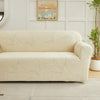 A beige sofa slipcover featuring a woven jacquard leaves pattern in a light neutral tone.