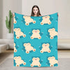 A teal blanket featuring a repeating pattern of cute, smiling bear-like characters.