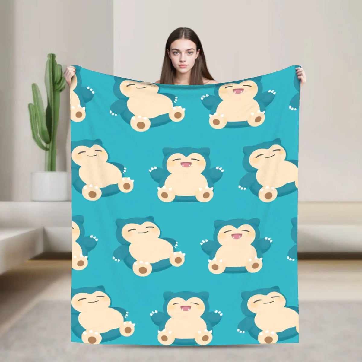 A teal blanket featuring a repeating pattern of cute, smiling bear-like characters.