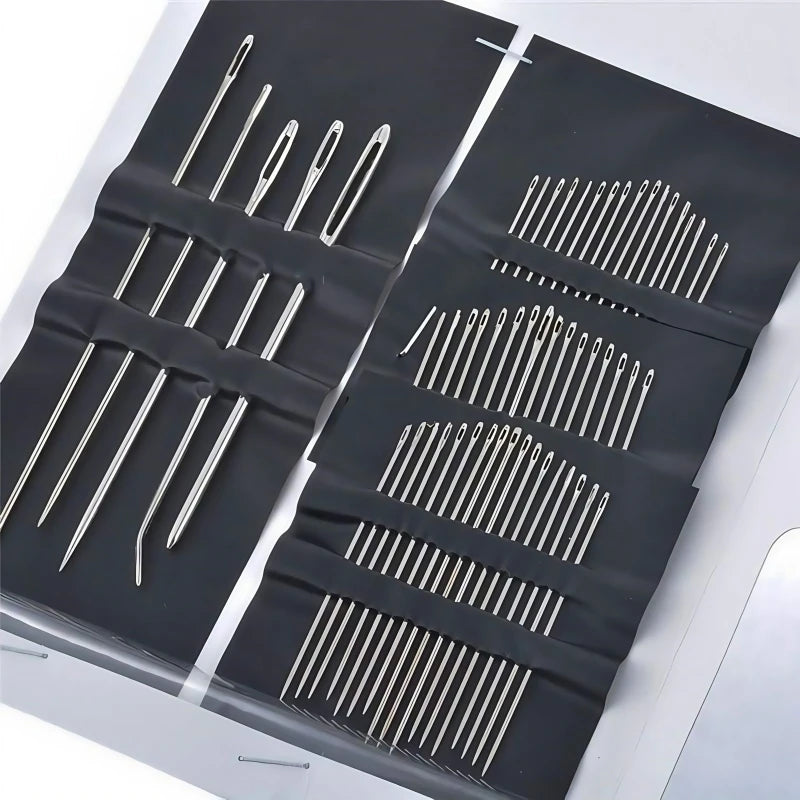 A set of stainless steel hand sewing needles arranged in rows on a dark surface.
