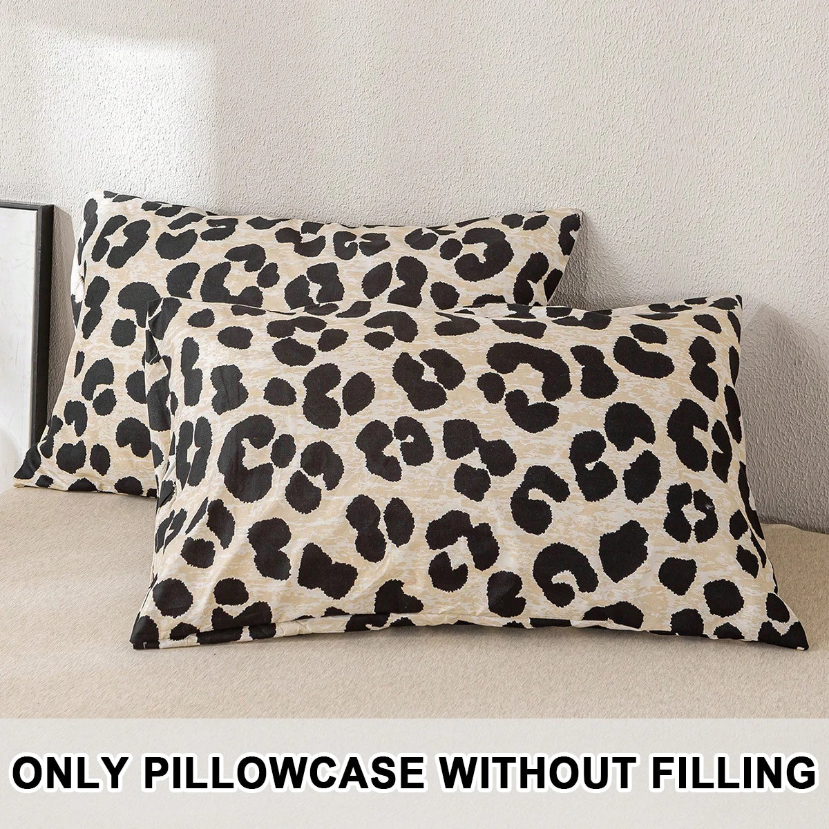 Two leopard print decorative pillow covers in beige and black spots displayed on a light surface.