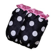 A black polka dot ruffle apron with pink trim and pockets.