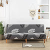 A gray sofa with black and white geometric leaf print slipcovers sits in a bright room.