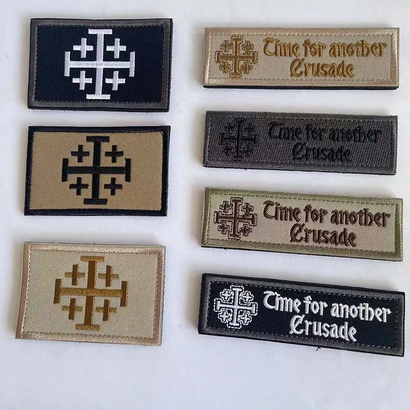 A collection of five embroidered patches featuring a cross design and the text Time for another Crusade on various colored fa