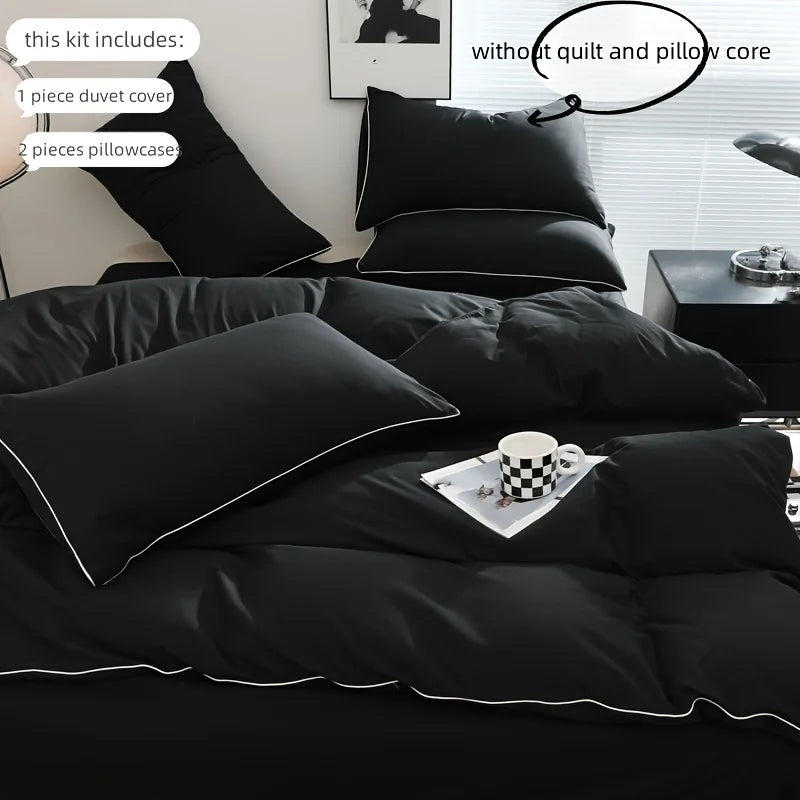 A black duvet cover set displayed on a bed, showing the duvet and pillowcases.