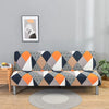 Geometric print spandex slipcovers on a sofa bed with an abstract painting in the background.