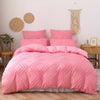 A pink bohemian grid tufted duvet cover set displayed on a bed with natural textures and light wood furniture.