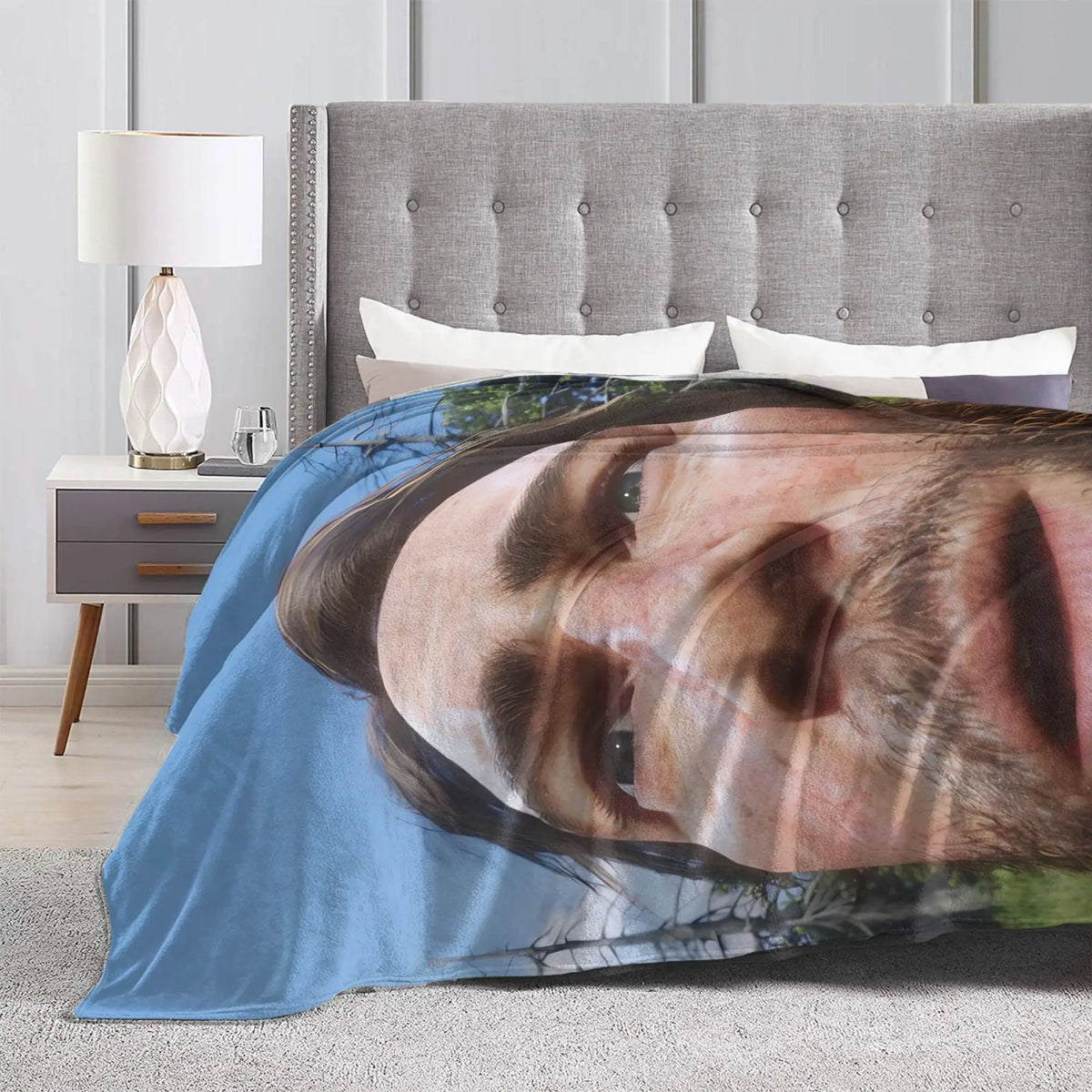 A blue flannel throw blanket featuring a photographic print of a man's face.