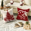A set of red and white Christmas snowflake tree pillows and a book on a gray rug.