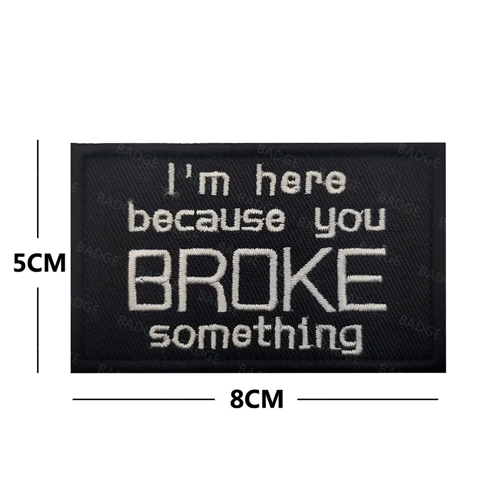 Black embroidered patch with white text that reads I'm here because you broke something