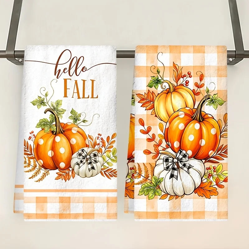Set of two kitchen towels featuring an orange pumpkin and plaid design for the fall season