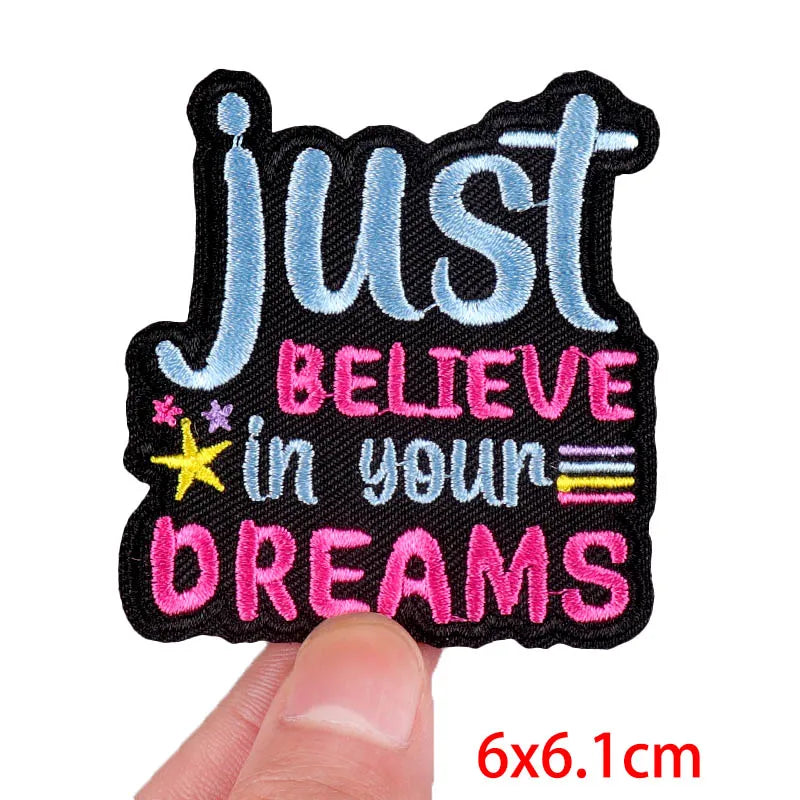 Black embroidered patch with blue text Just believe in your dreams