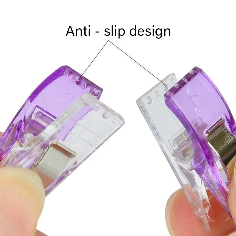 Close-up view of purple plastic sewing clips with an anti-slip design being held by a finger.
