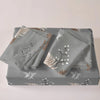 A set of three gray duvet covers featuring a delicate white and gold floral plant print.
