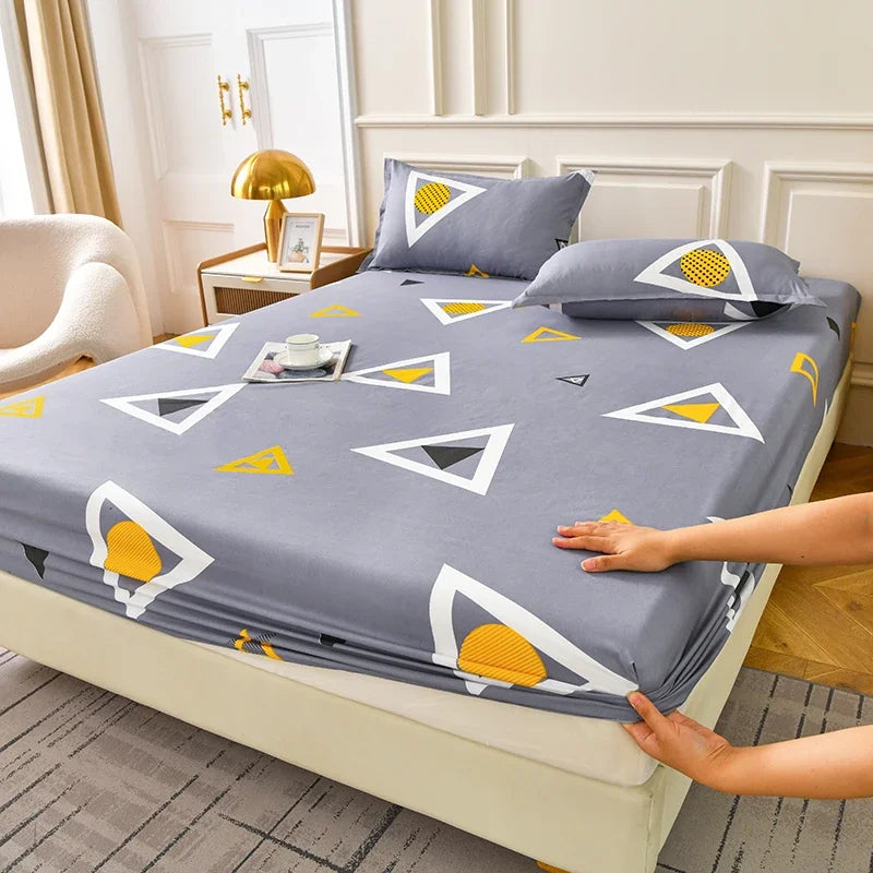A gray fitted sheet set with yellow geometric patterns and matching pillowcases is displayed on a bed.