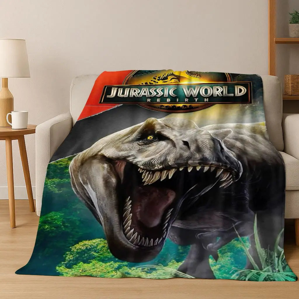 A graphic print of a roaring Jurassic World dinosaur head on a blanket.