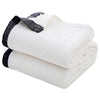 A stack of white and black muslin throw blankets rolled up.