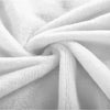 A close-up of a white plush flannel blanket with a soft, folded texture.