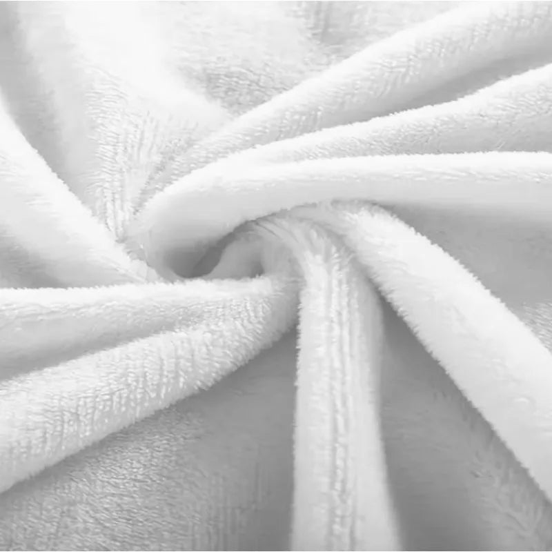 A close-up of a white plush flannel blanket with a soft, folded texture.