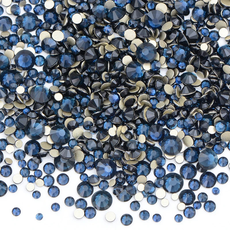 A pile of mixed blue and gold clear glass rhinestones for DIY crafts.