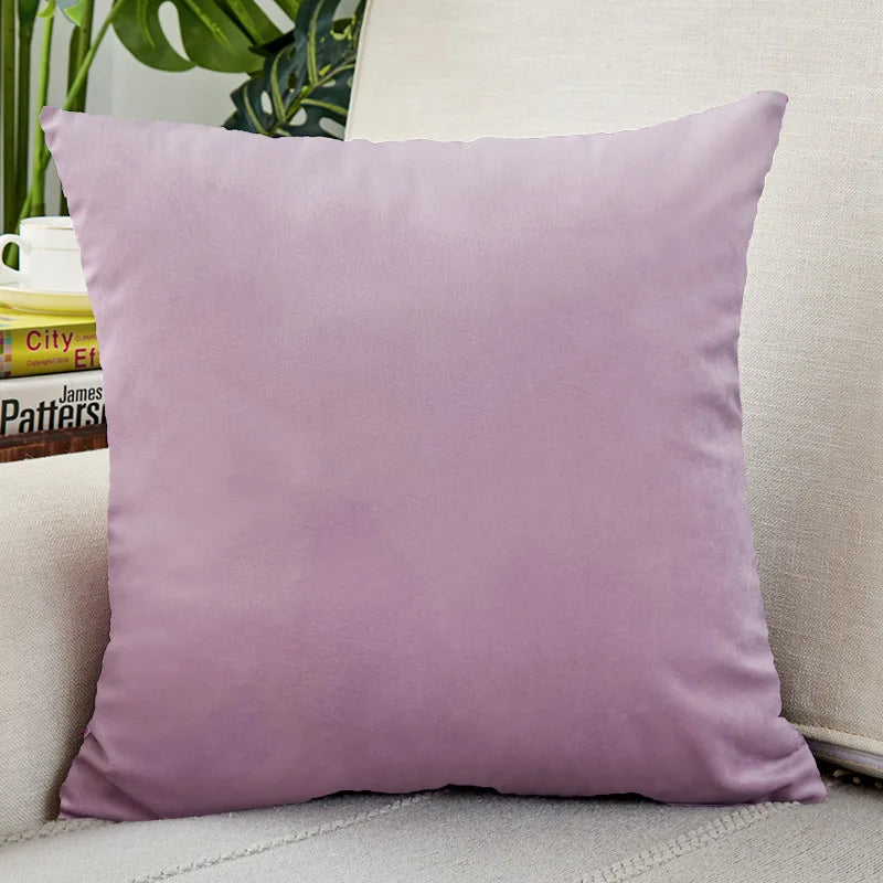 A square lavender velvet cushion cover resting on a light-colored sofa.