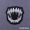 Black embroidered patch featuring a skull design with white feathers on a gray background.