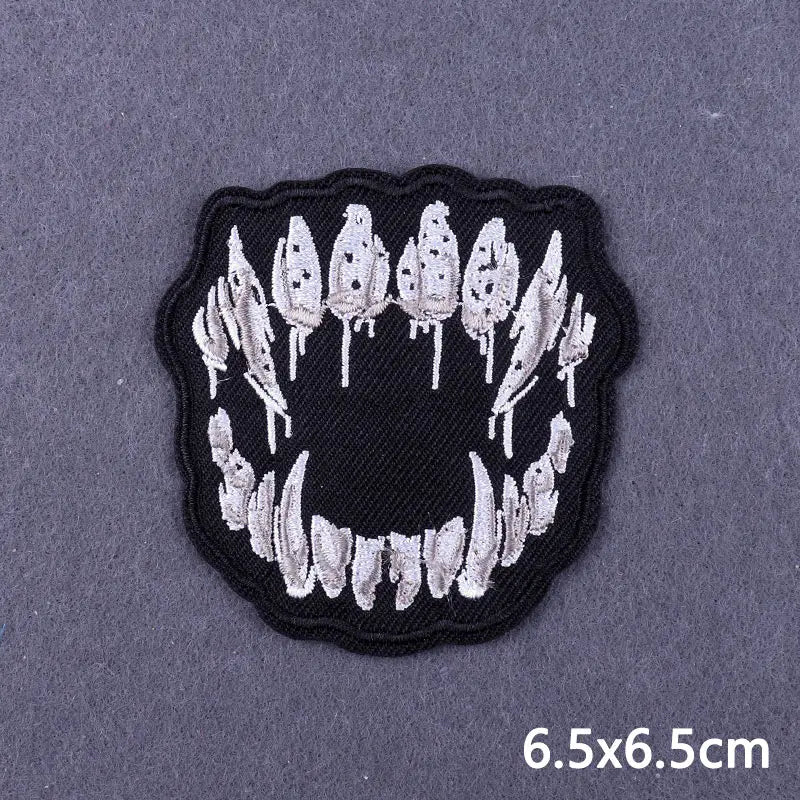 Black embroidered patch featuring a skull design with white feathers on a gray background.
