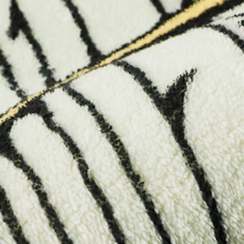 Close-up of a white and black striped faux fur rug texture.