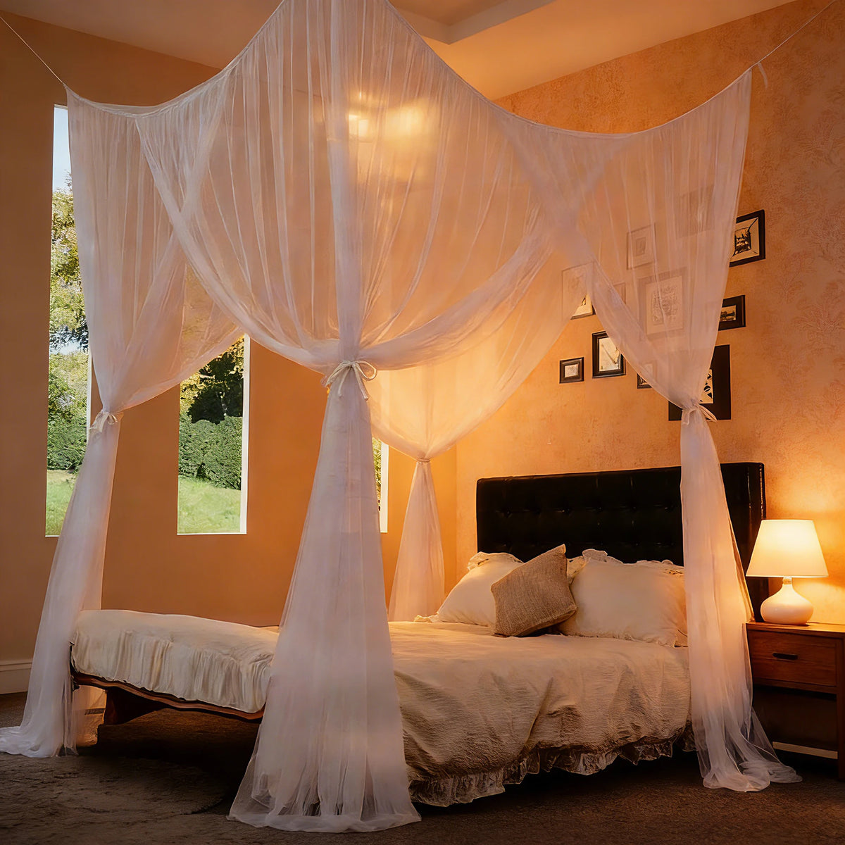 A bedroom featuring a square mosquito net bed canopy draped in sheer white fabric over a bed.
