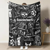 A black blanket featuring a retro punk print with skulls, guns, and text like Suicideboy and grey 59.