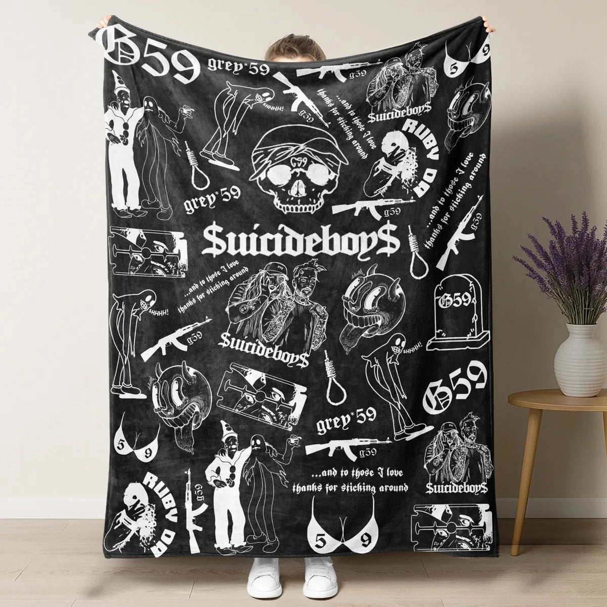 A black blanket featuring a retro punk print with skulls, guns, and text like Suicideboy and grey 59.