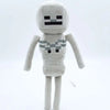 A light gray stuffed dragon plush toy with a pixelated face and body texture.