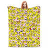 A pink cartoon plush throw blanket featuring yellow, smiling, fluffy characters.