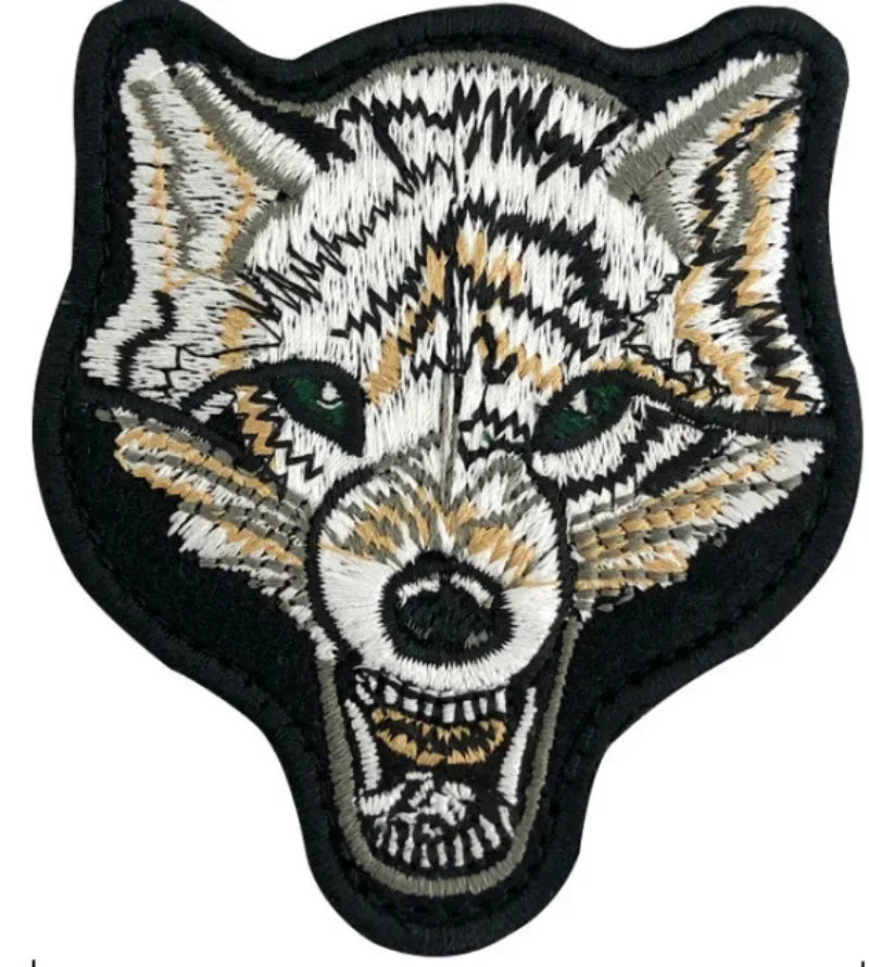 Embroidered fox face patch with white, gray, and tan fur details on a black background