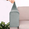 A close-up of a gray velvet sofa armrest cover being held by a hand, resting on a light pink sofa.