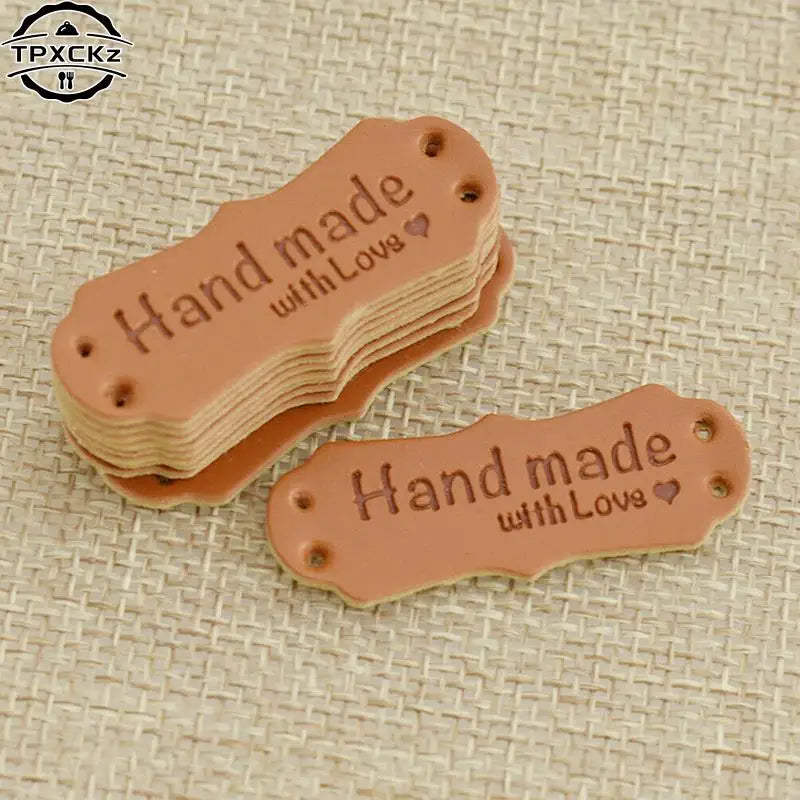 A stack of 50 PU leather embossed tags with the text Handmade with Love on a light brown background.