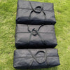 Three black durable Oxford cloth storage bags stacked on green grass.
