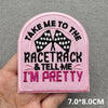 Pink embroidered patch with black text that reads Take me to the racetrack and tell me I'm pretty